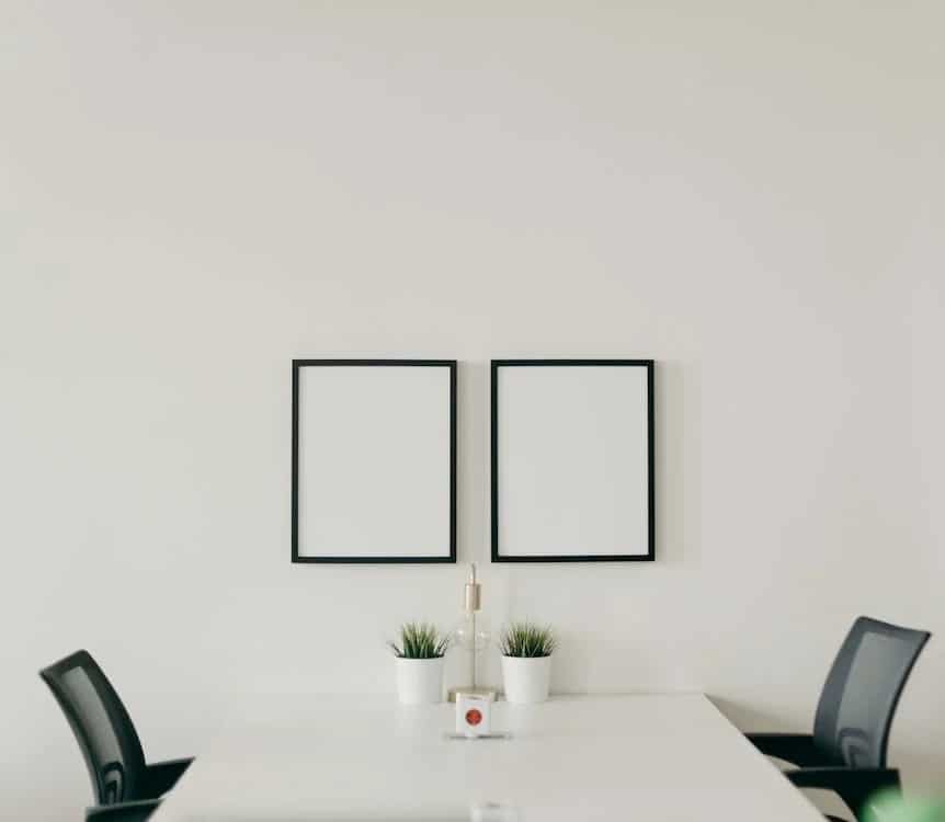 Alt. tag: Two empty photo frames over a white desk, symbolizing the importance of innovation in the tech startup world.