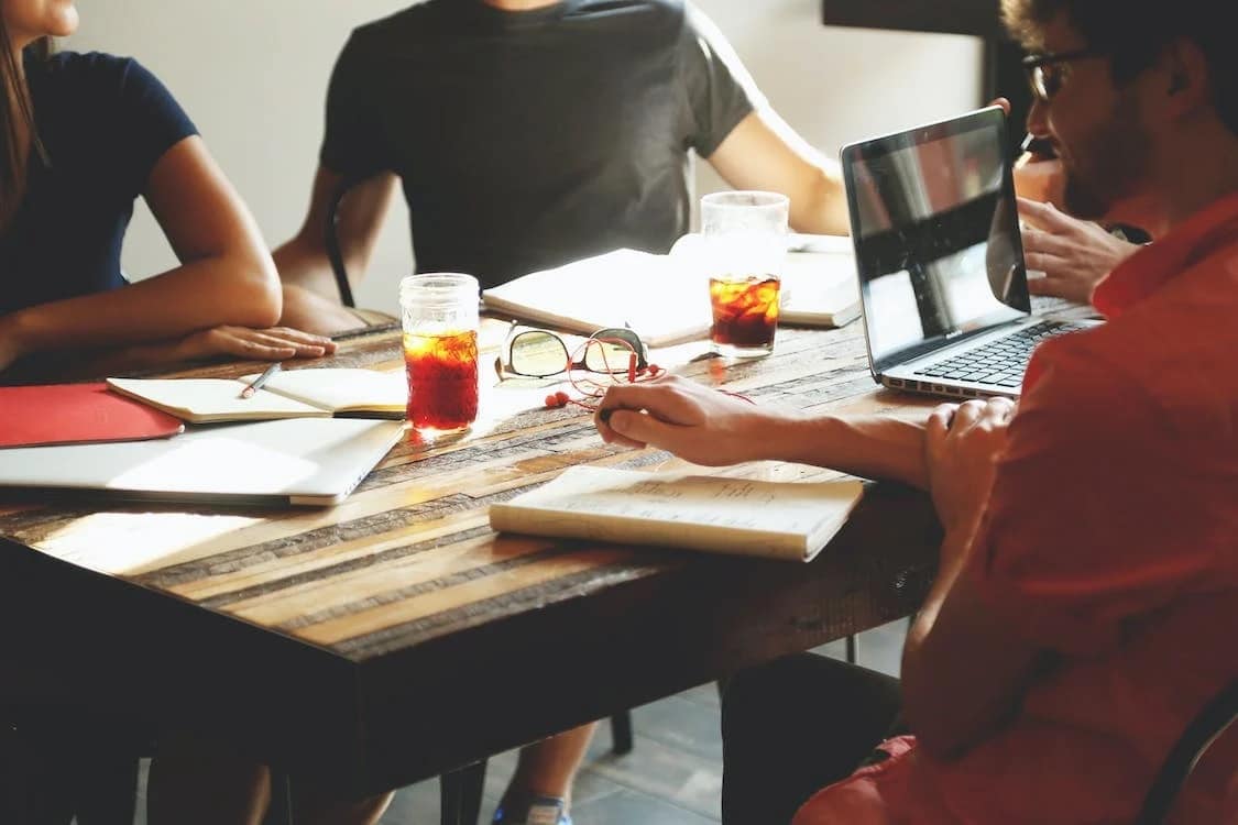 A group of people having a meeting over drinks.