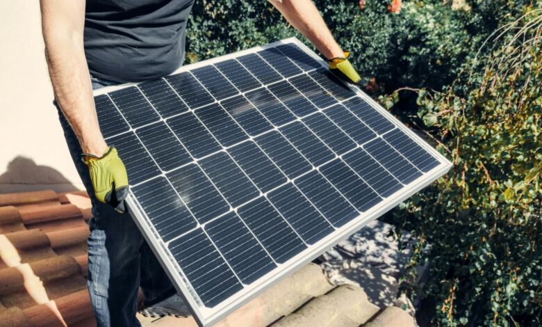 A guy carrying a solar panel