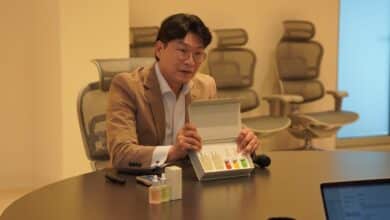 a man sitting at a table with a box of vials