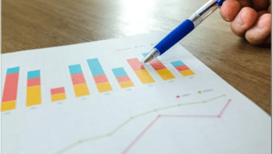 A person pointing at a paper with metrics with a blue pen