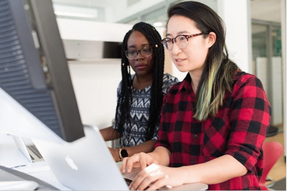 Two people looking at a laptop display